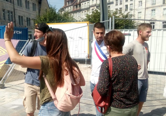 Un conseiller municipal ceint de l'écharpe tricolore sur une manifestation du 14 juillet 2020
