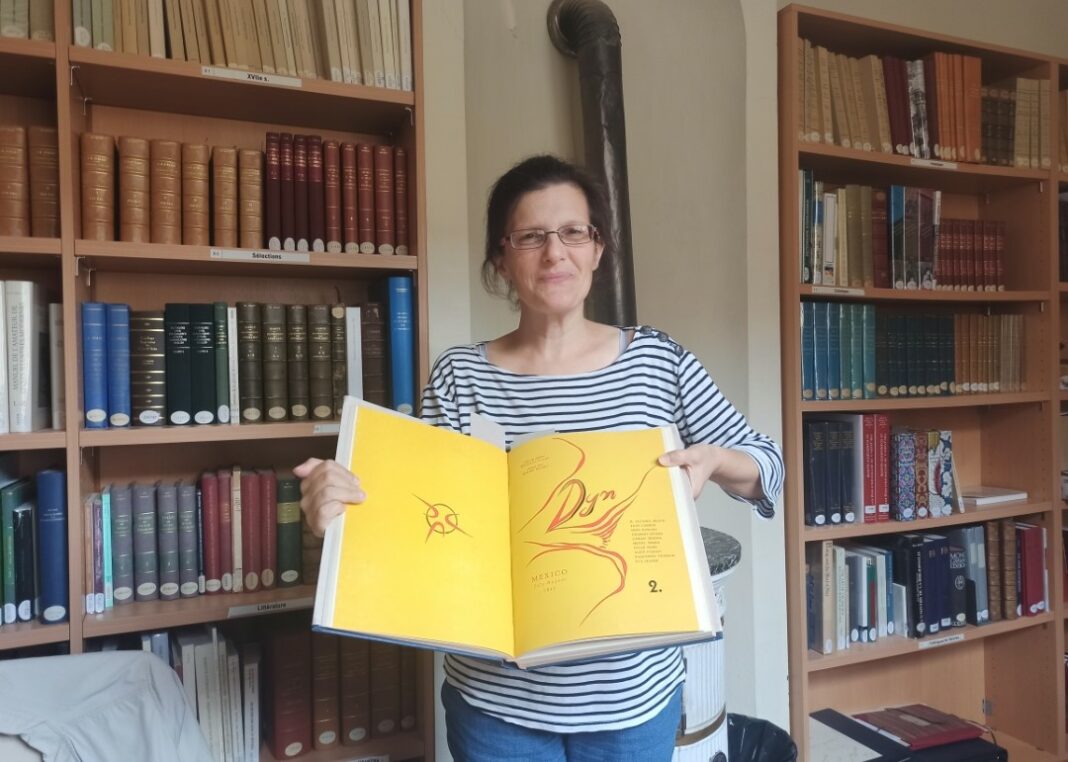 Hartwig Bérénice, bibliothécaire, présentant la revue artistique acquise récemment par la bibliothèque d’étude et de conservation.
