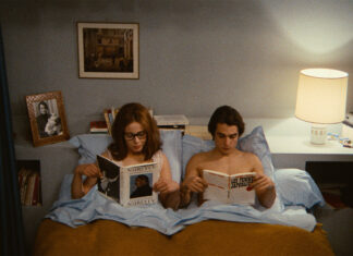 Deux personnes assisent dans leurs lit.