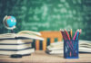 Salle de classe avec des livres, des crayons et un globe
