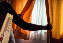 Personne qui ferme un rideau et une apparition d'un thermomètre