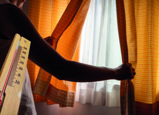 Personne qui ferme un rideau et une apparition d'un thermomètre