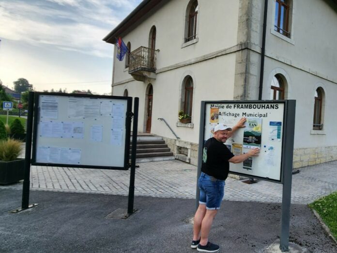 Franck Villemain colle des affiches