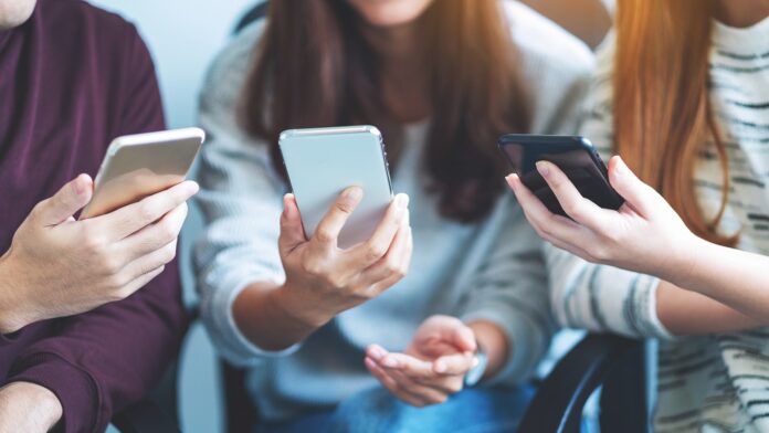 trois personnes avec un téléphone