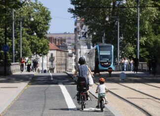 Deux personnes en vélo le long du Tramway à Besançon