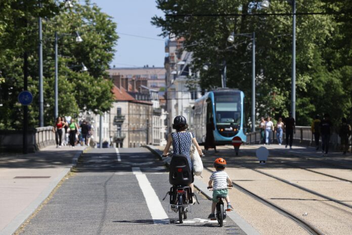 Deux personnes en vélo le long du Tramway à Besançon