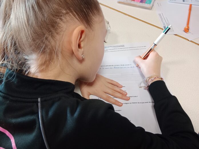 Journée de la laïcité Jeune fille qui note sur une feuille