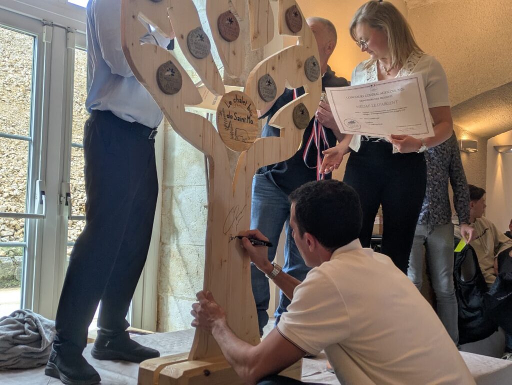 Quentin Fillon-Maillet signant une dédicace sur trophée